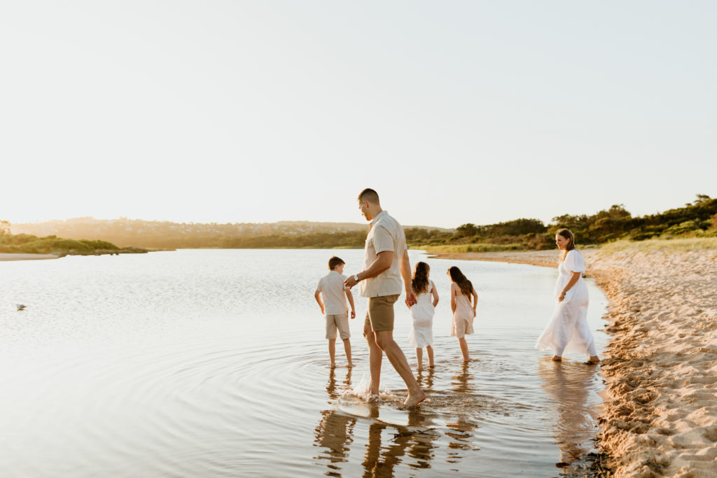 Family of five playing in the beach water in sydney