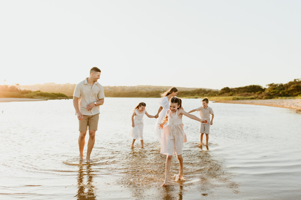 Family of five playing in the beach water in sydney
