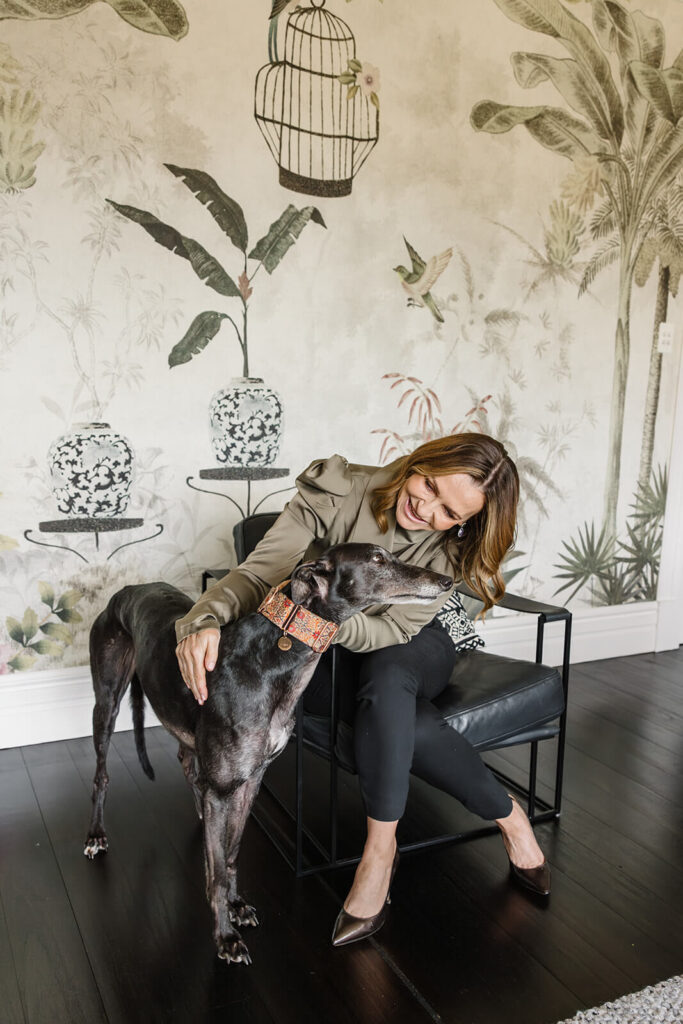 Female entrepreneur embracing her dog in a sophisticated and luxe interior backdrop