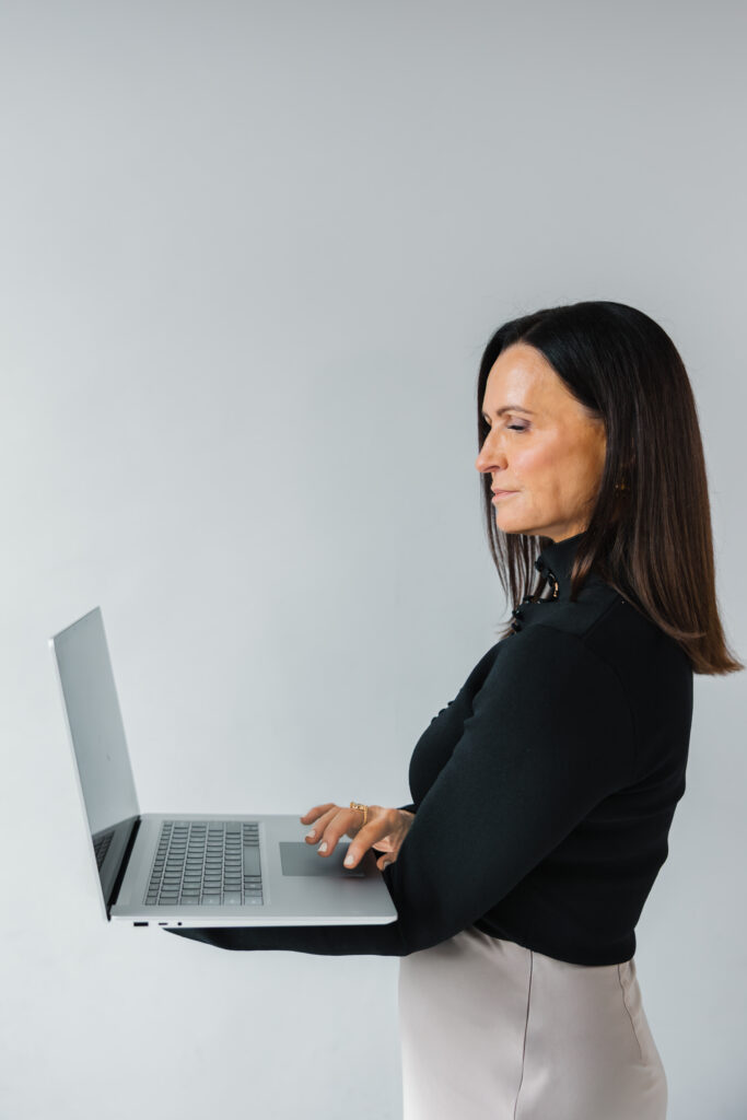 Professional woman working on laptop during personal branding photoshoot